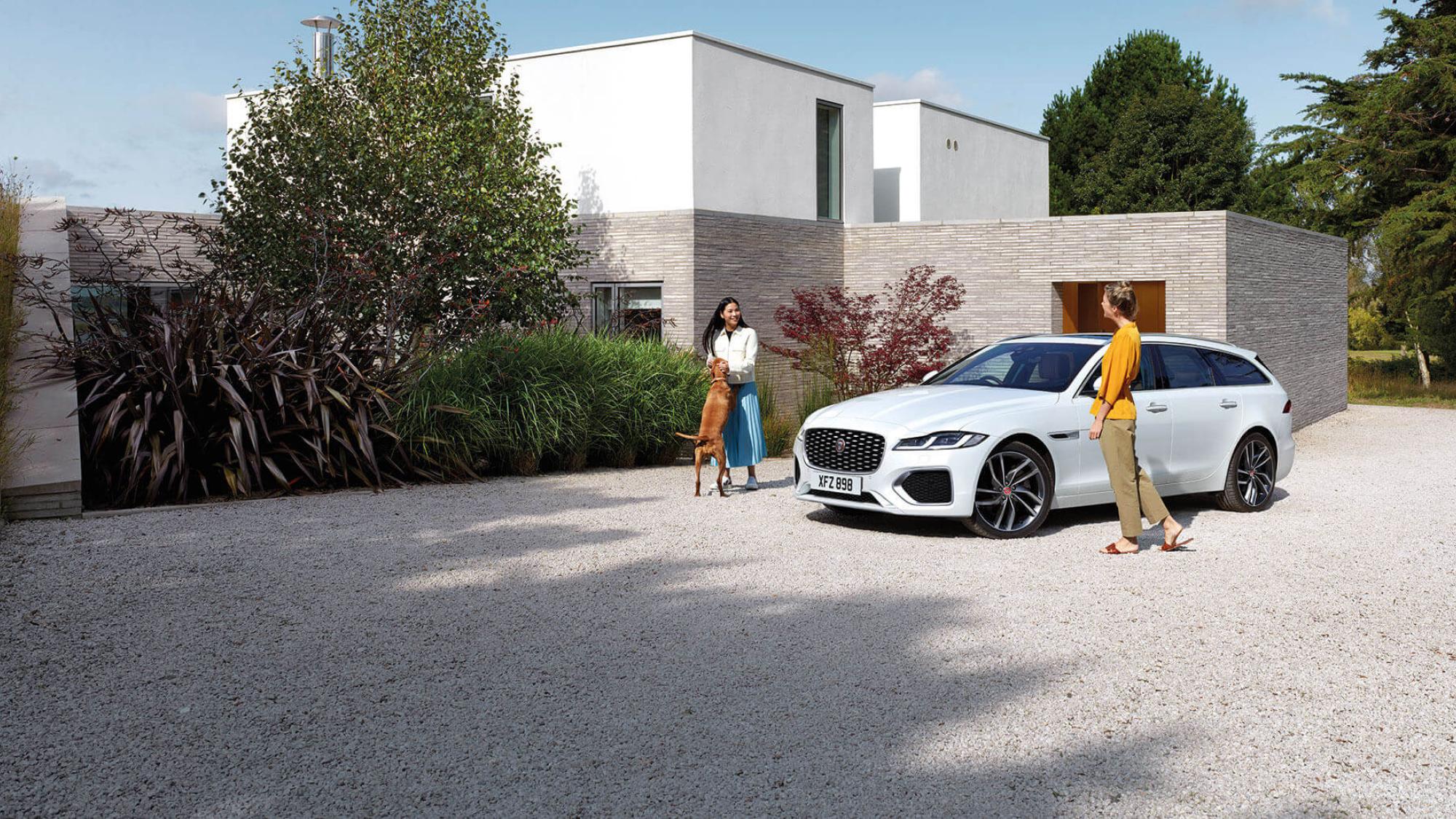 Ein Jaguar Automobil auf einem großen Platz vor einem Haus